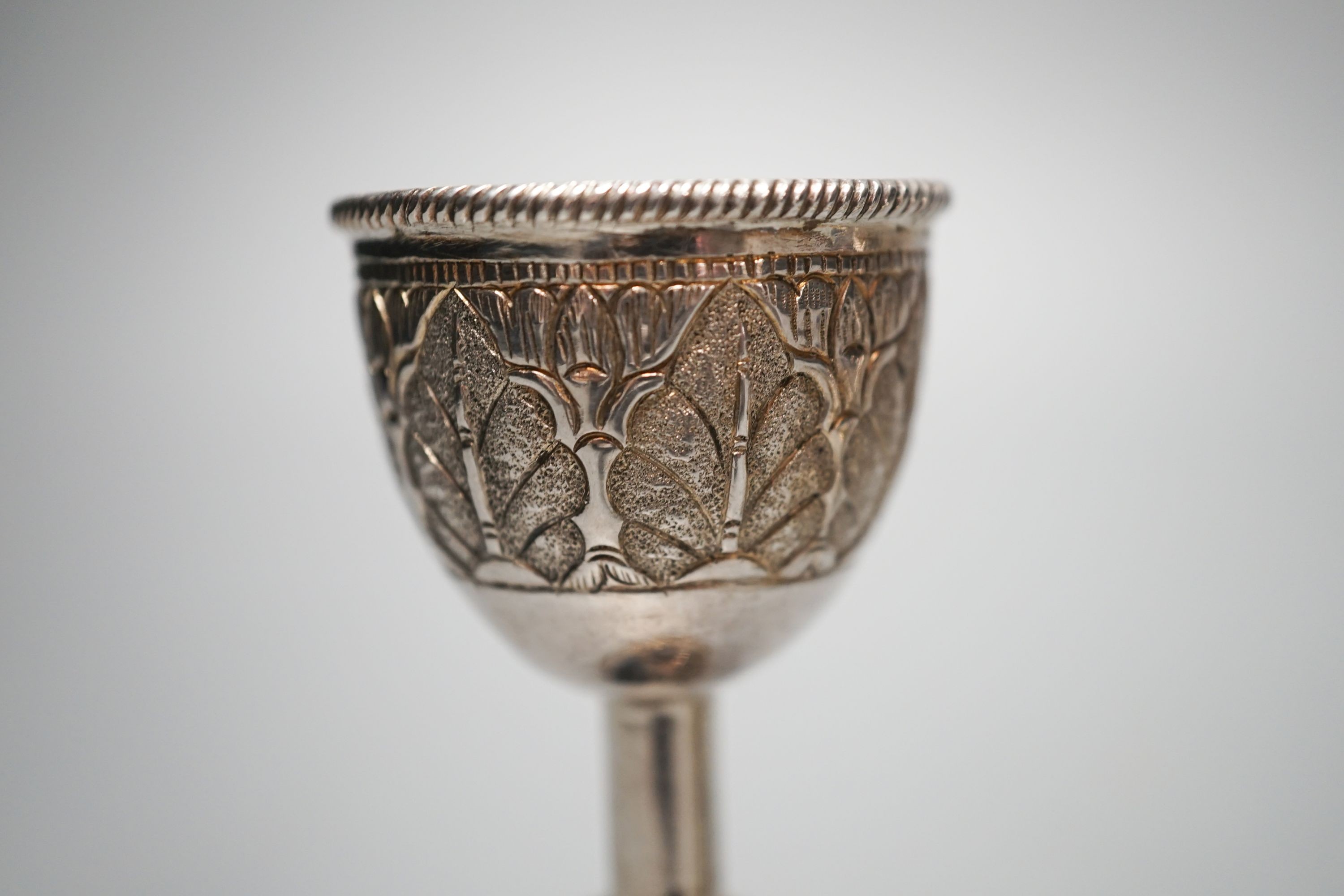 Two early 20th century Russian white metal tots, a sterling beaker, white metal double measure and a case pair of silver mounted glass salts.